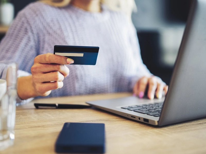 Person using a laptop to pay online by card - Quick and easy financing with approved credit from Novakoski Floor Covering in Anderson, IN
